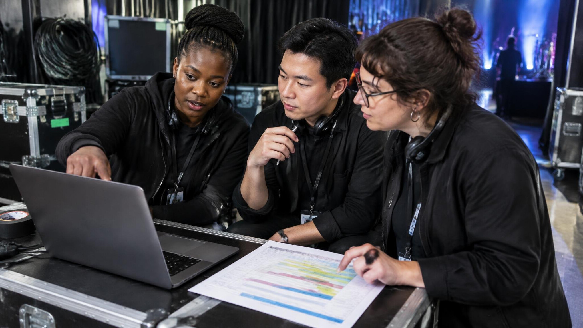 Production team collaborating around a production schedule